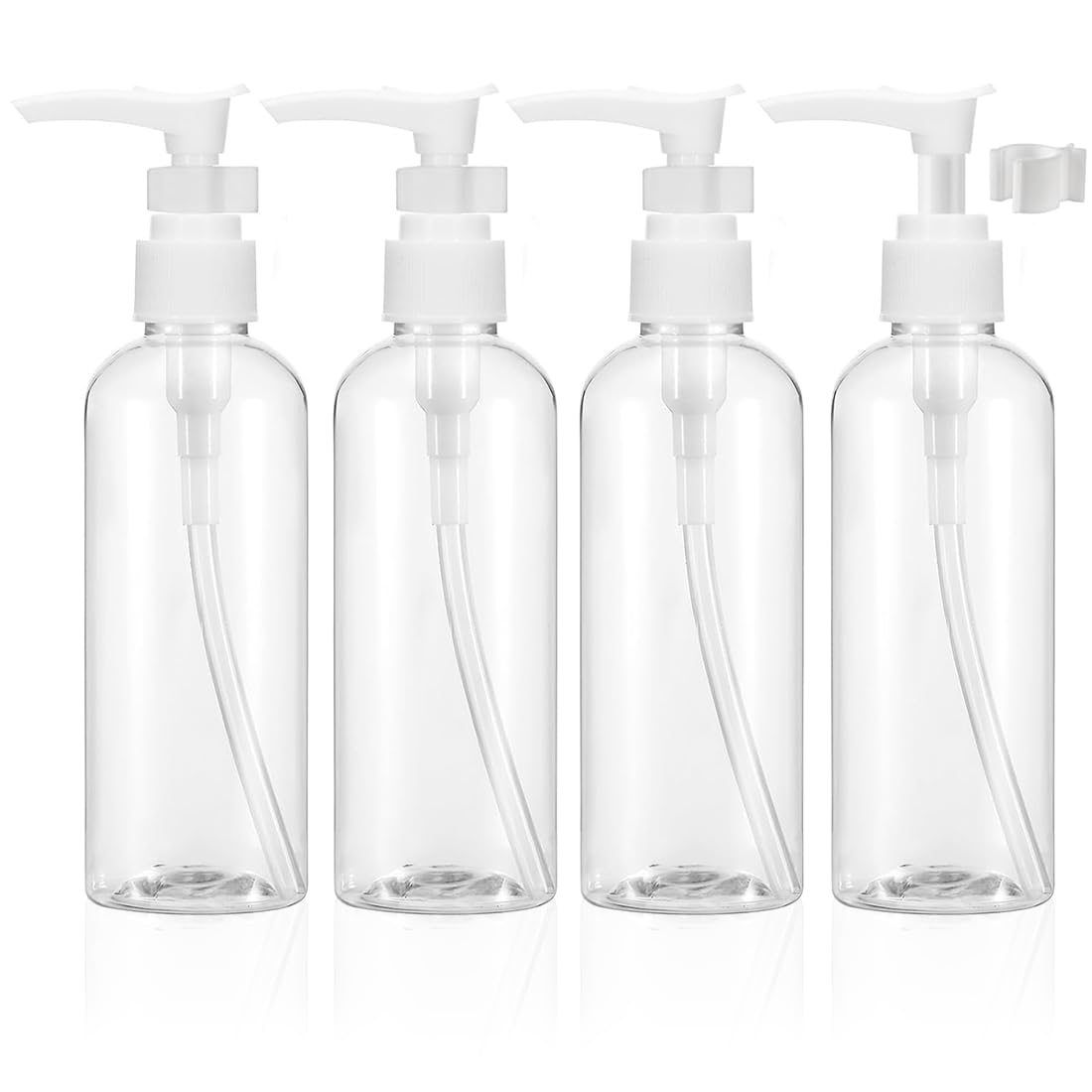 Quatre flacons de voyage transparents à pompe, rechargeables et compacts, posés près d’une trousse de toilette