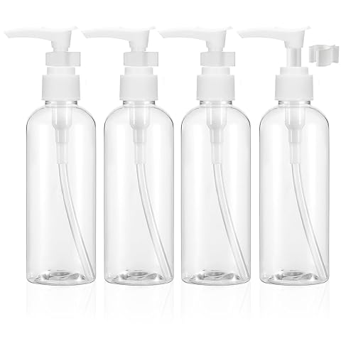Quatre flacons de voyage transparents à pompe, rechargeables et compacts, posés près d’une trousse de toilette