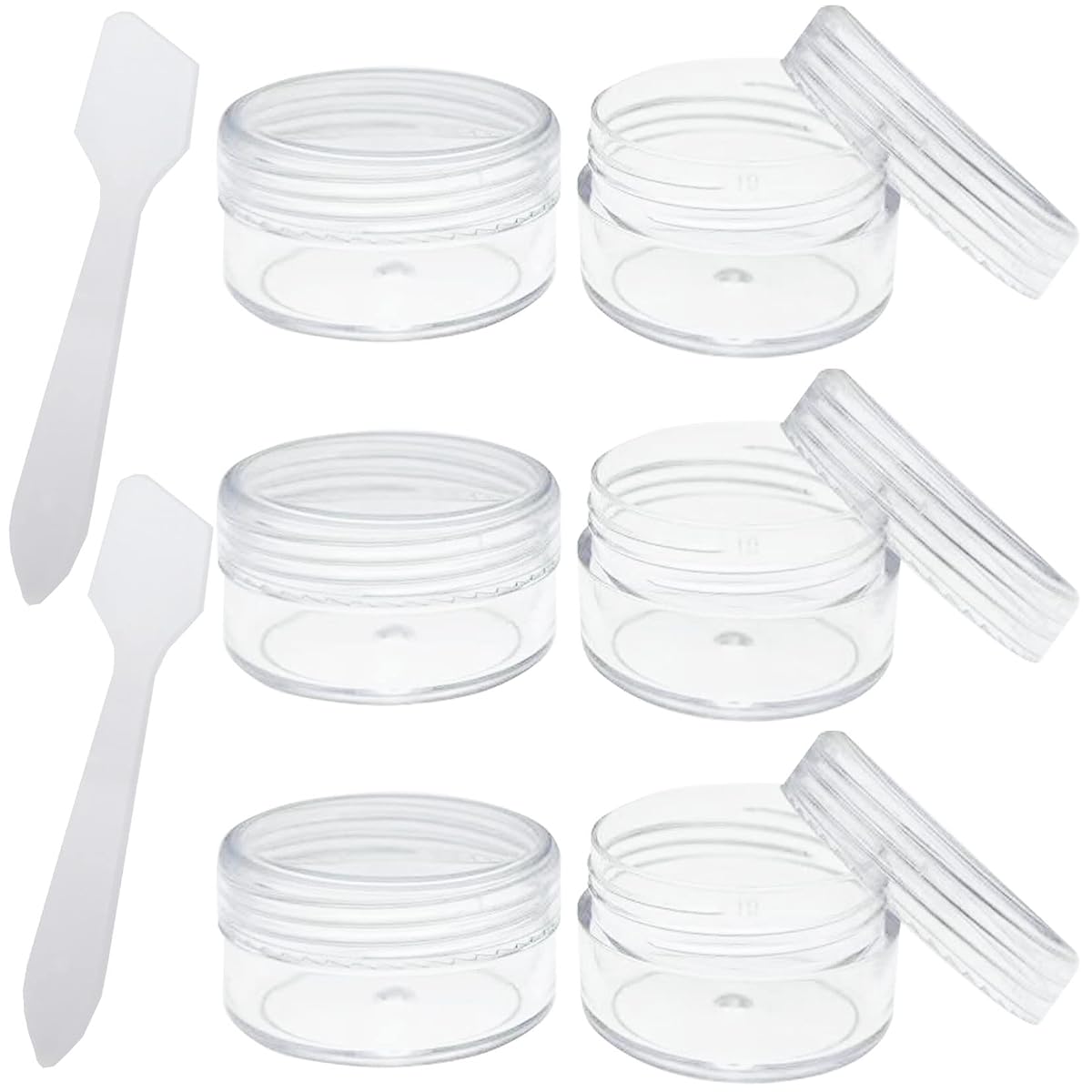 Six pots de voyage transparents de 10 ml et deux mini spatules posés près d’une trousse.