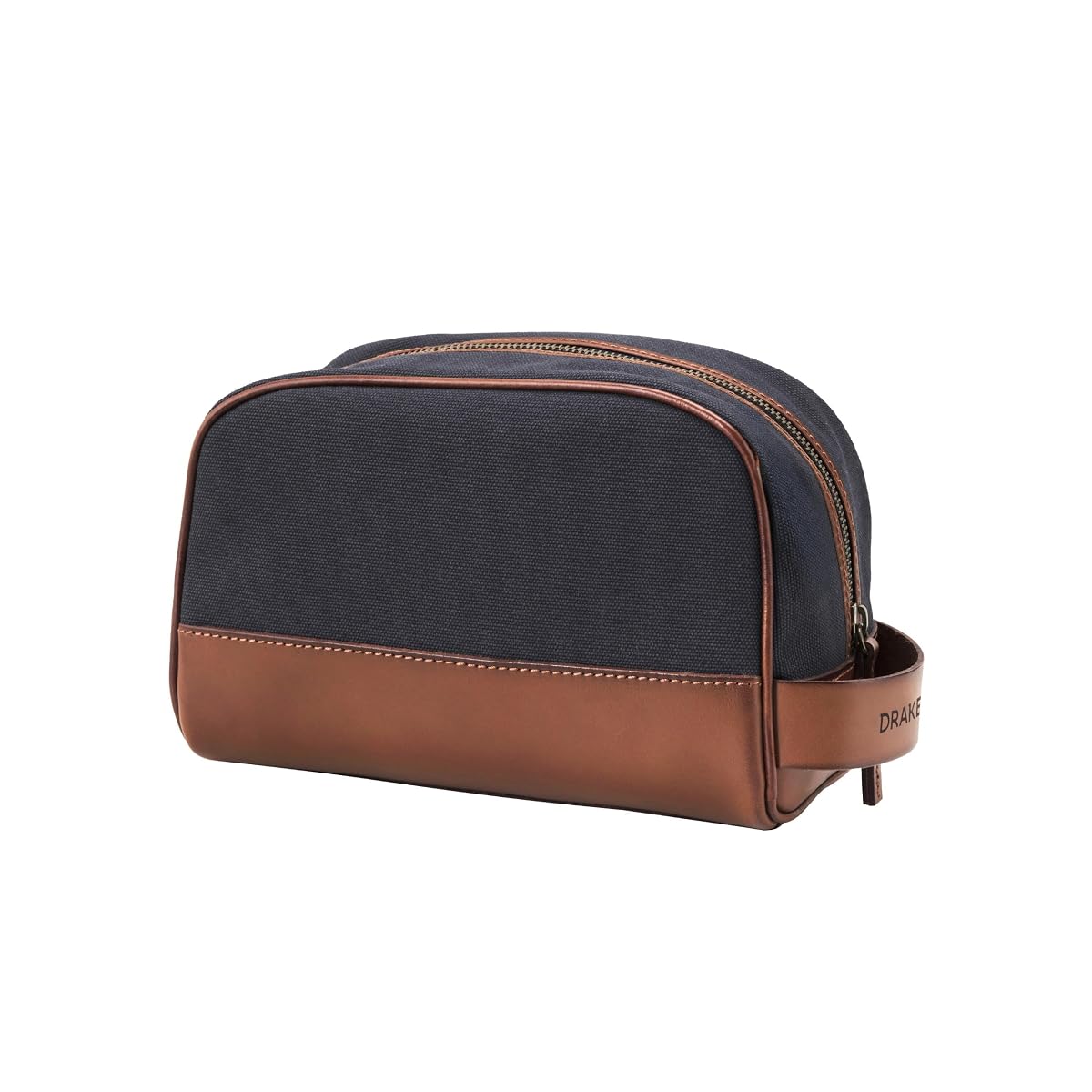 Trousse de toilette classique en toile bleu-marine et cuir, avec son sac de protection posé à côté