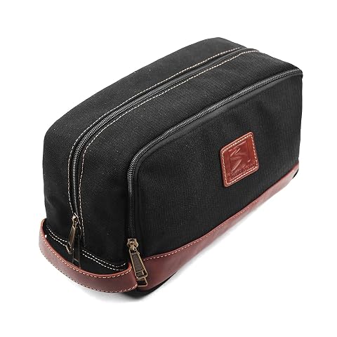 Trousse de toilette noire en toile avec poignée latérale et poche zippée, dans un décor de voyage sobre