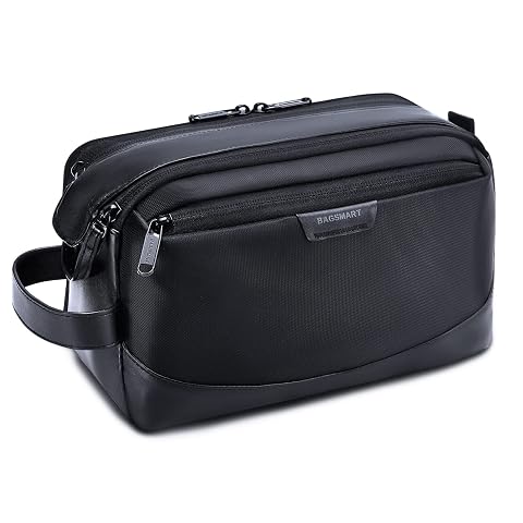 Trousse de toilette noire Bagsmart avec poignée et double fermeture éclair, posée dans un décor de voyage sobre.