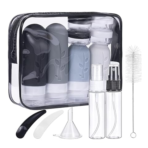Kit de voyage en silicone noir avec flacons, pots et accessoires de toilette disposés sur un fond sable
